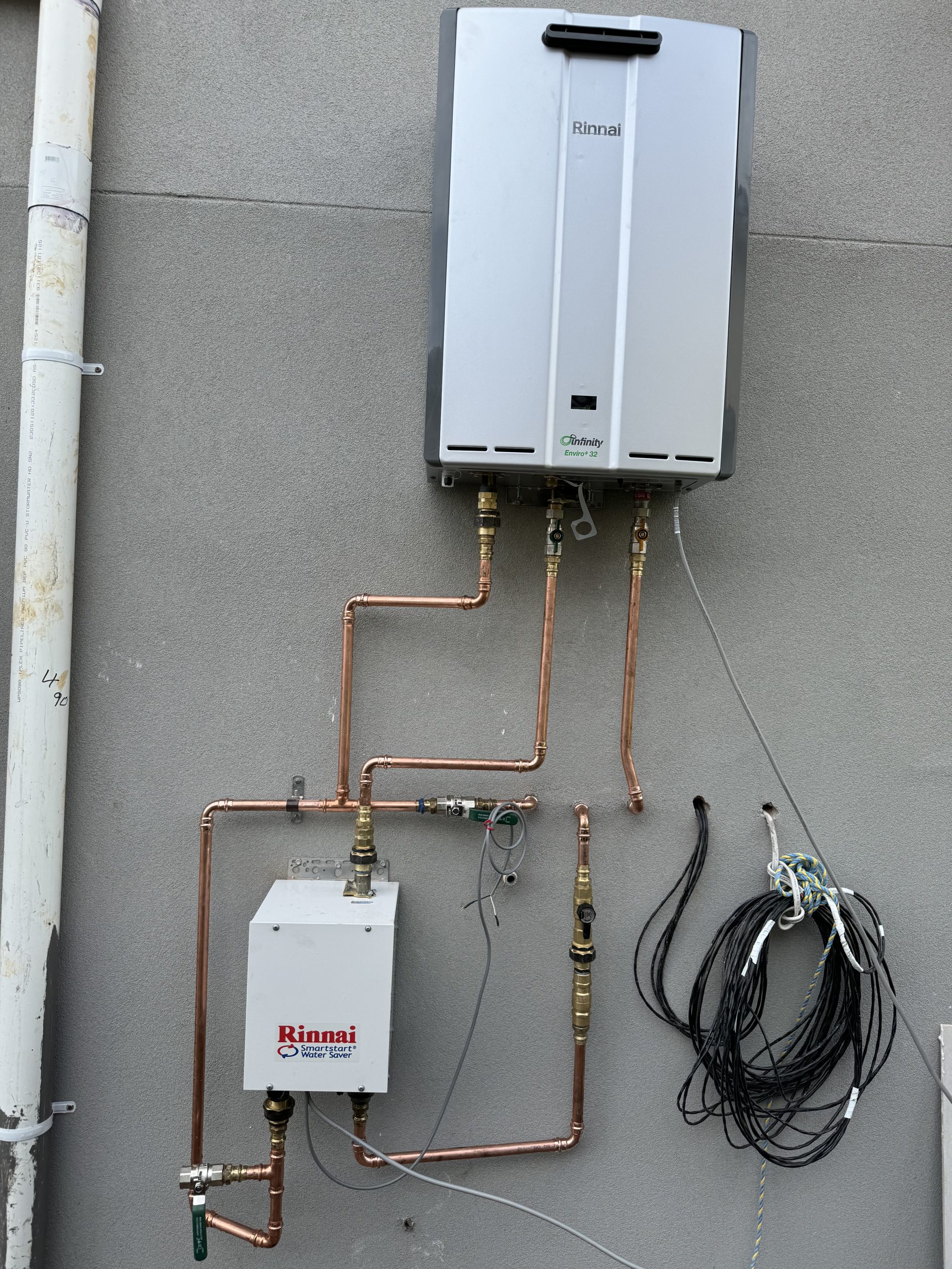 connected by exposed copper plumbing pipes and a bundle of black electrical wires.